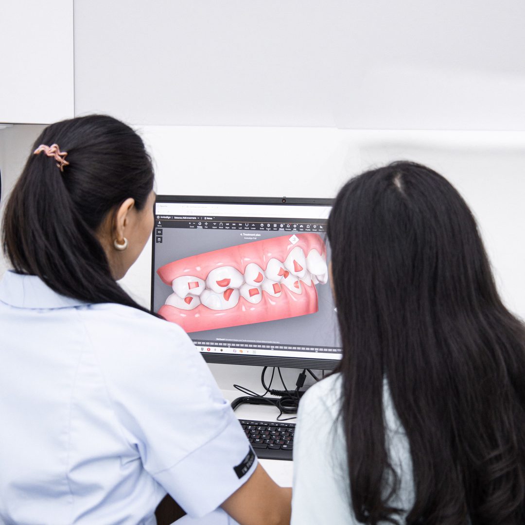 Implantes de carga inmediata - Clínica Dental Dentinos Dentista y paciente revisan en pantalla la planificación digital 3D de un tratamiento de implantes
